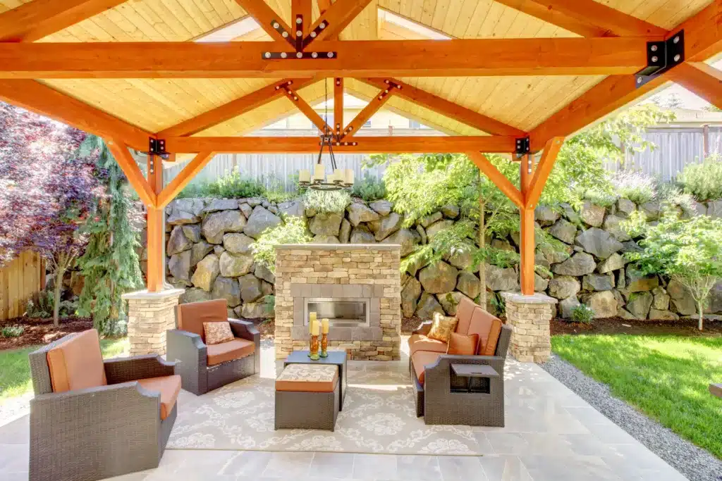 Perfect Your Patio in Summer with These 7 Tips Exterior covered patio with fireplace and furniture. Wood ceiling with skylights. Your Patio in Summer